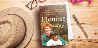 copy of Lioness book on table with hat glasses and pen