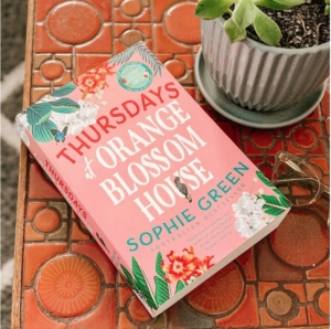 Thursdays at Orange Blossom House book on a table beside a pot plant